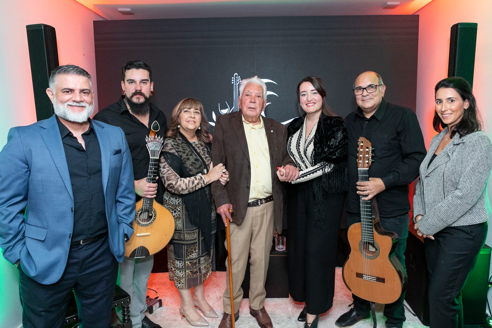 Convidados e músicos reunidos durante encontro cultural na sede do Clube